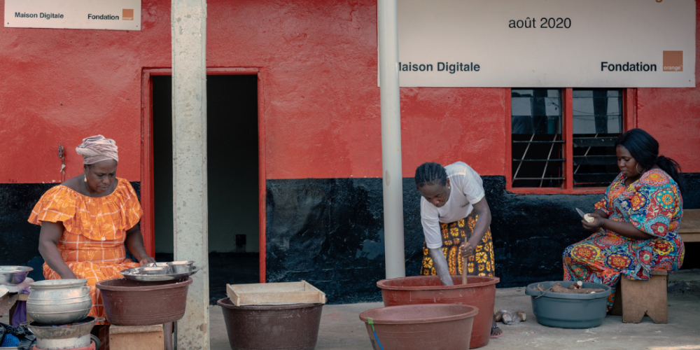 Trois femmes installées dans la rue vendent du manioc.